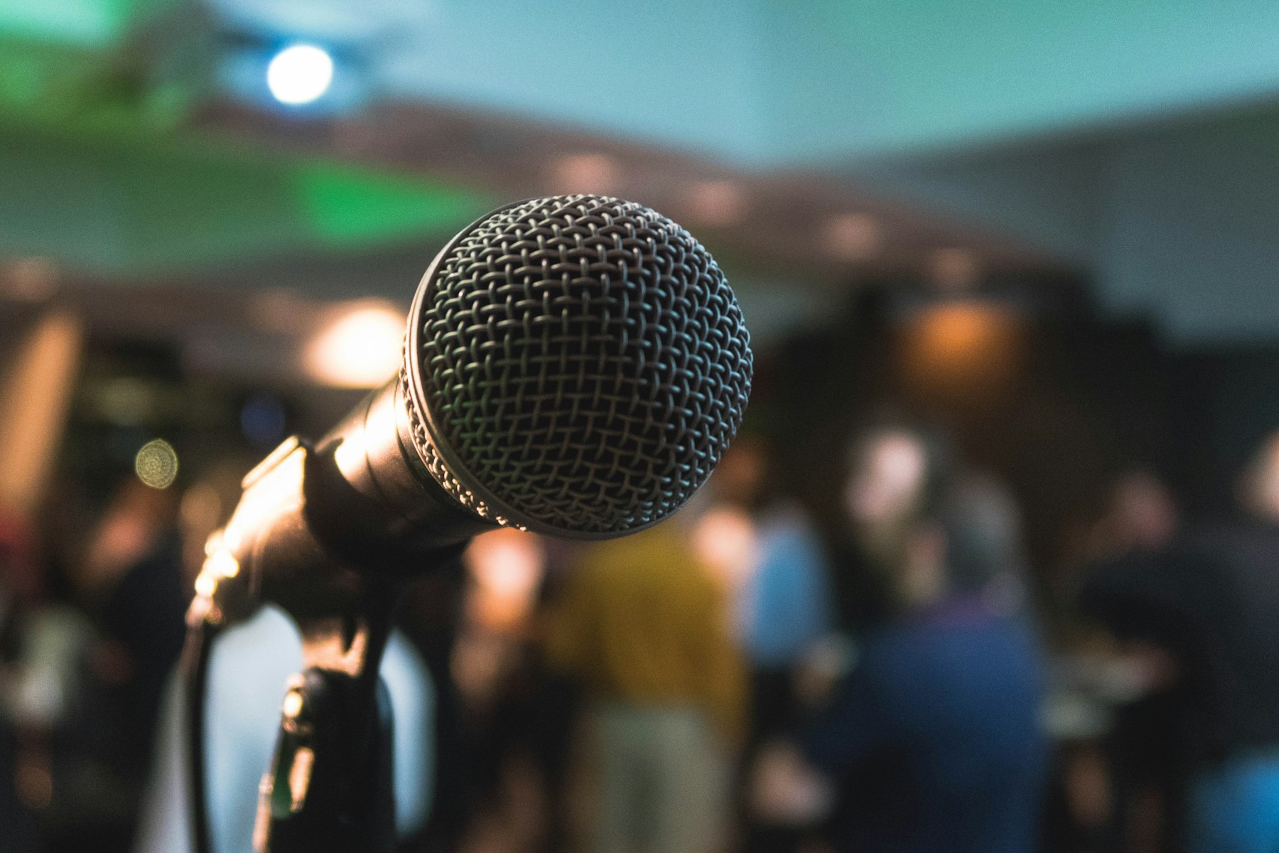 Speaker addressing a corporate audience from a lit stage.